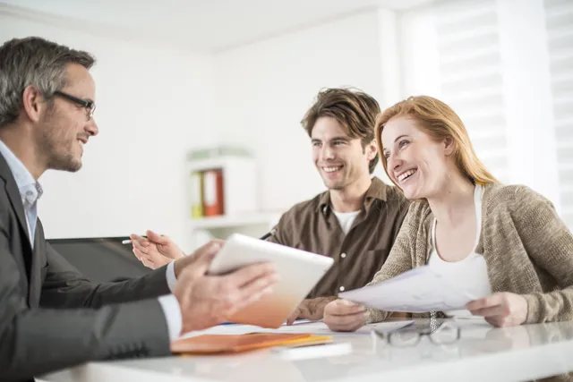 A couple consults with a professional on accumulation and maintenance trusts, reviewing documents and advice.