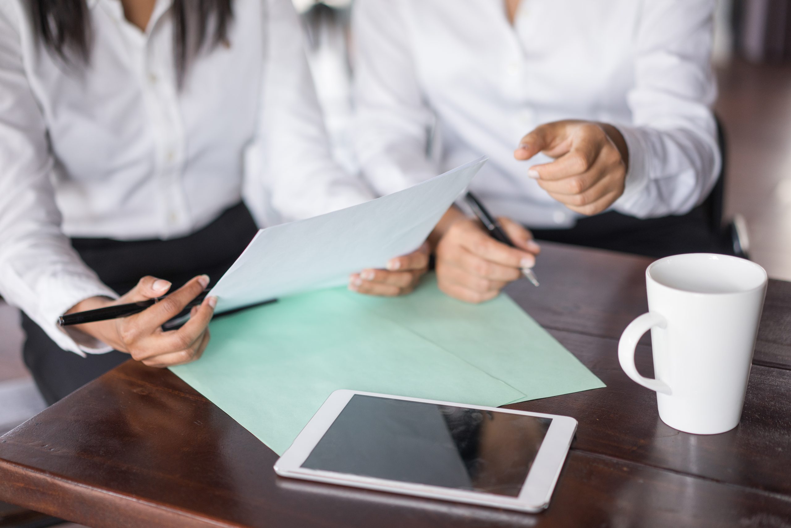 Two people reviewing documents and notes for a step-by-step guide to obtaining a grant of probate in NSW.