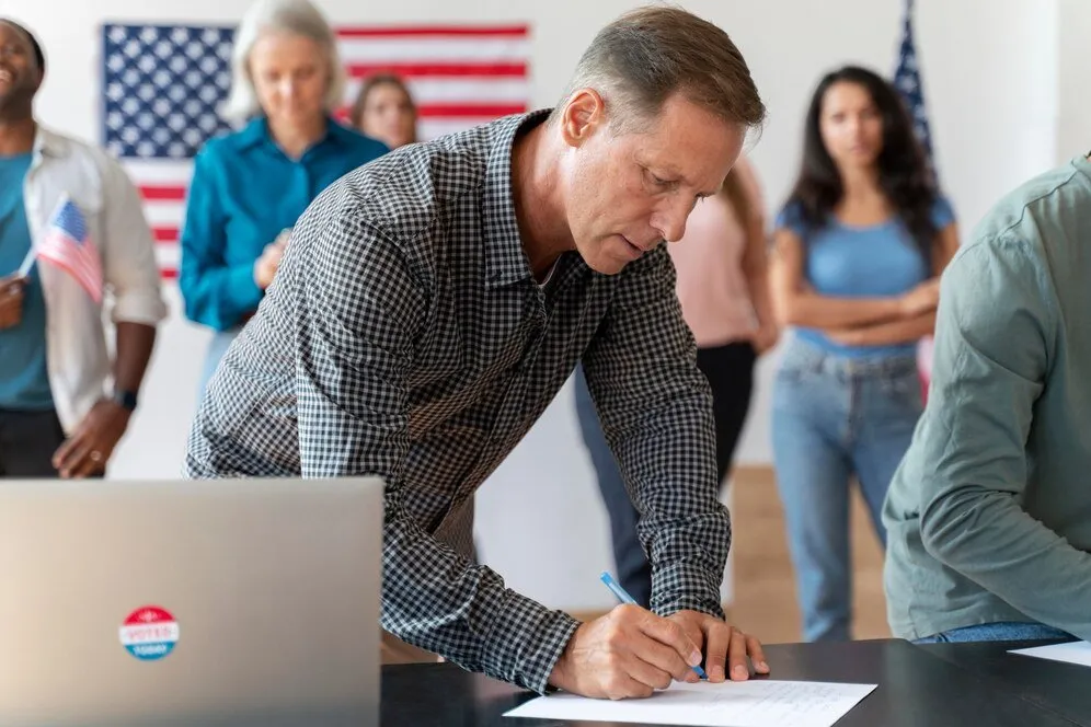 Man signing a document at a polling station.