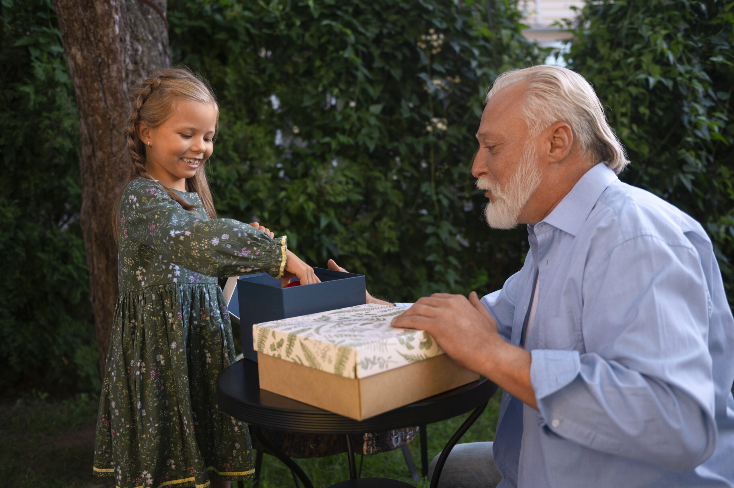 Grandfather and granddaughter exchanging gifts in garden