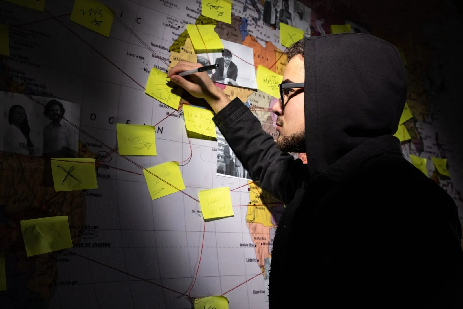 Person reviewing a world map with sticky notes, planning NSW family provision claim evidence.