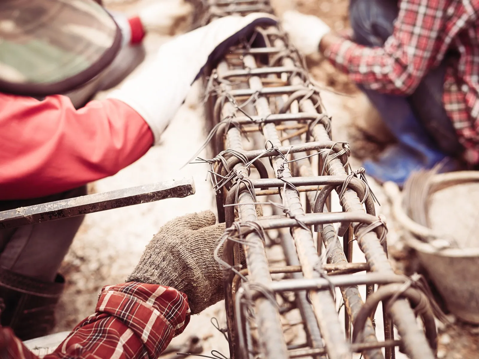Construction workers installing reinforcing steel for a fence.