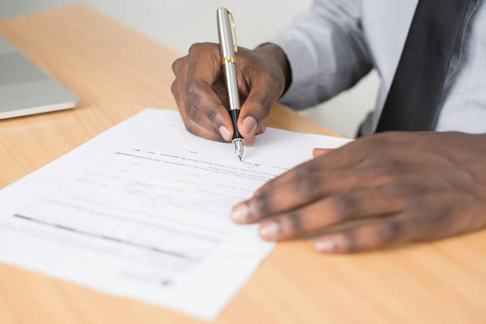 Person signing a legal document with a pen. Statement of Testamentary Intention.