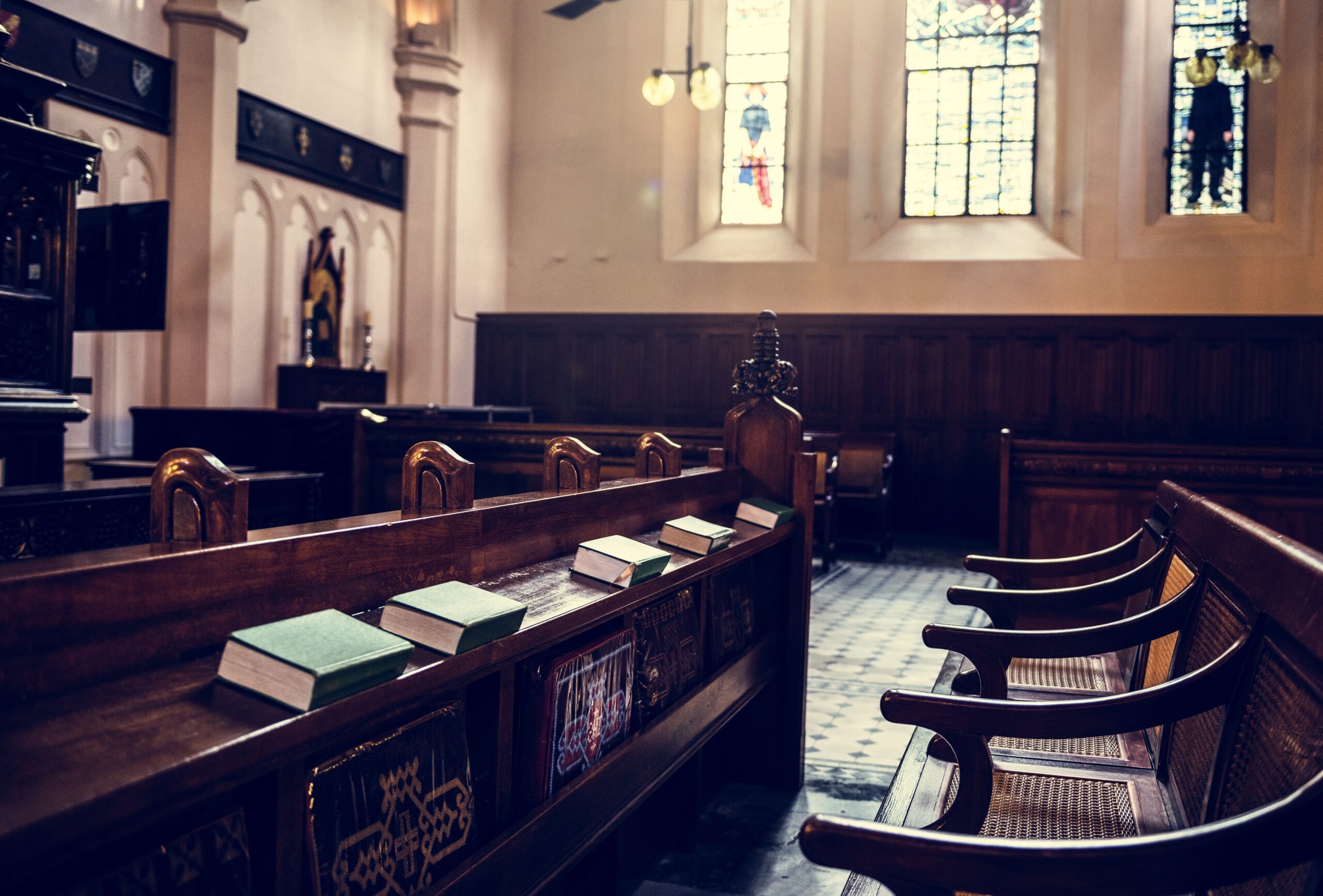Empty courtroom benches in the NSW Supreme Court with stained glass windows