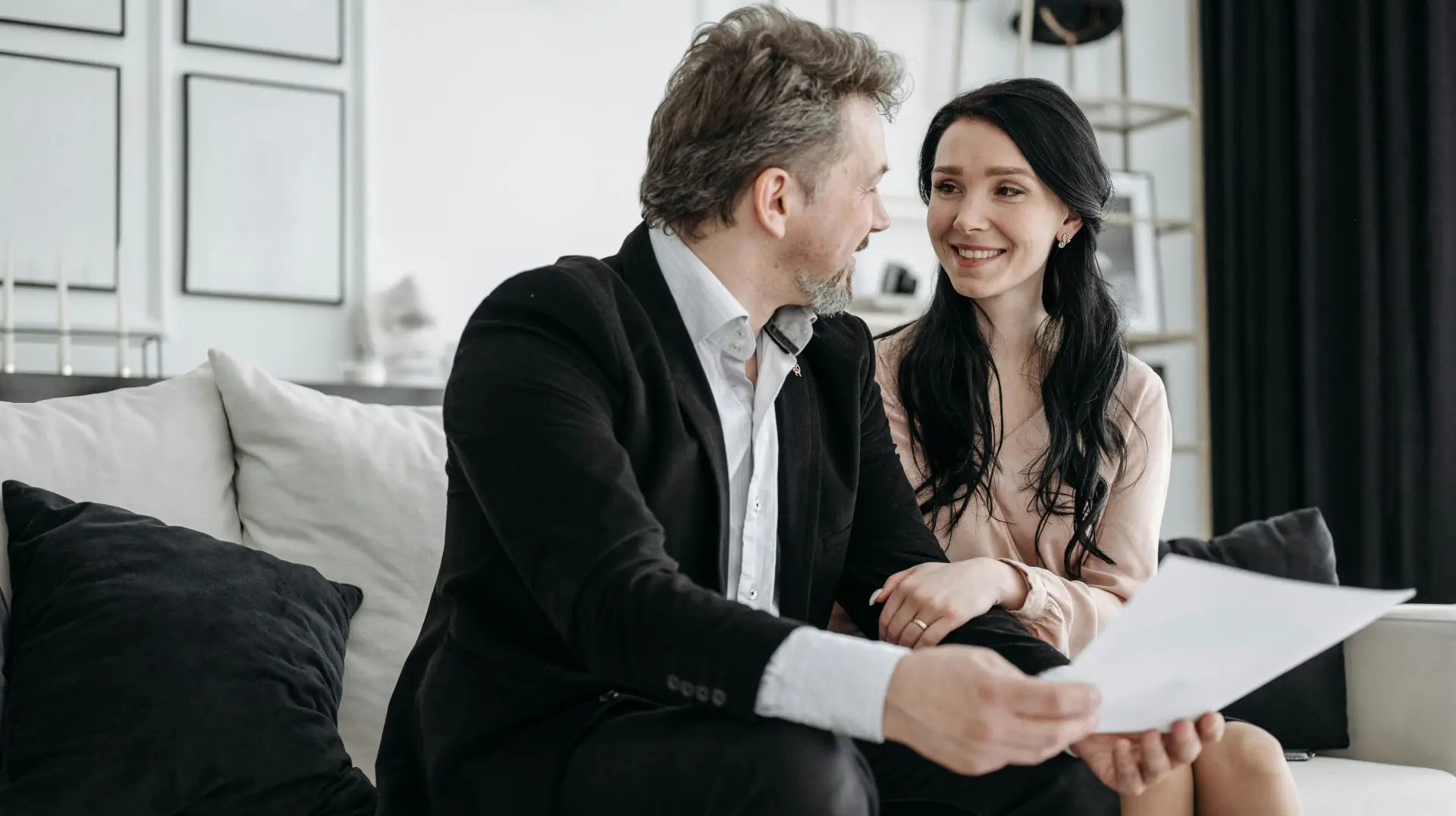 Man and woman reviewing a will or estate document, smiling at each other