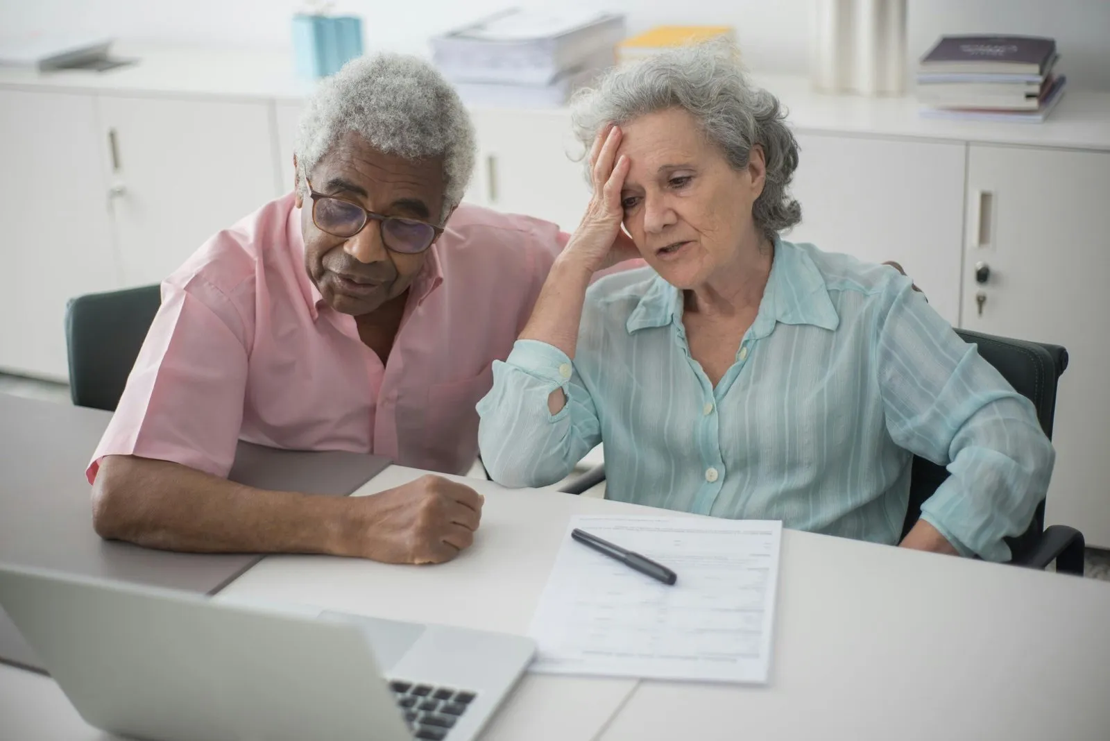 Older couple reviewing documents, possibly related to a will challenge. The woman appears concerned.