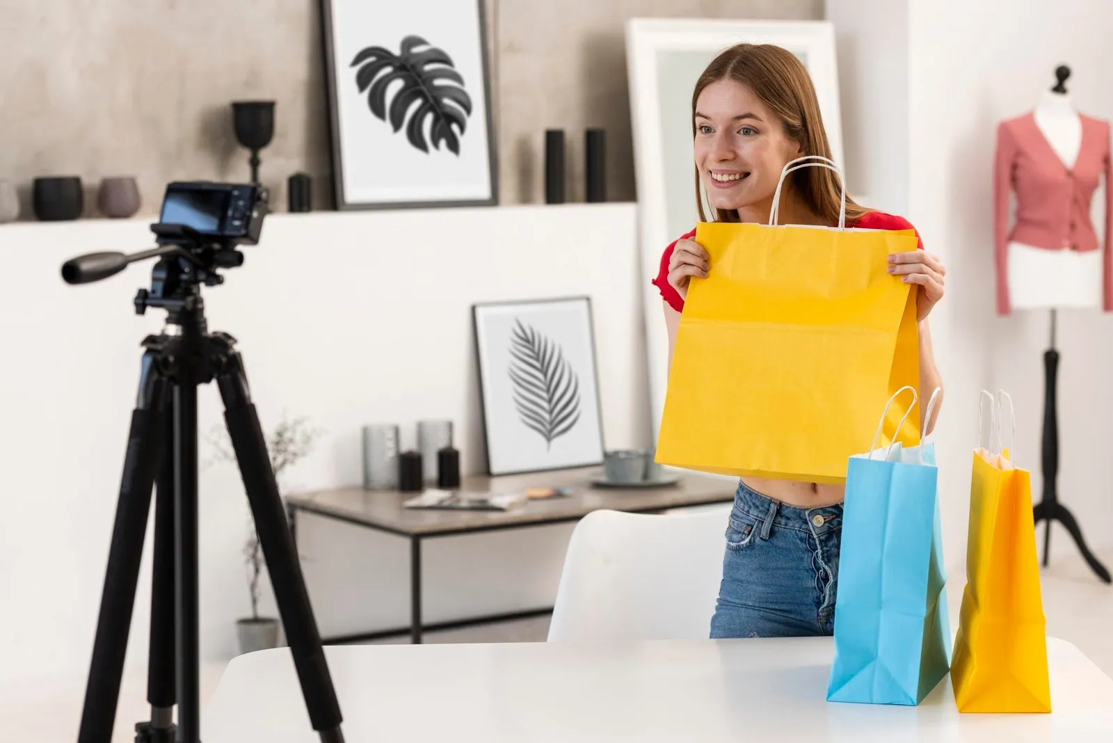 Young woman filming a haul video with shopping bags for her YouTube channel.