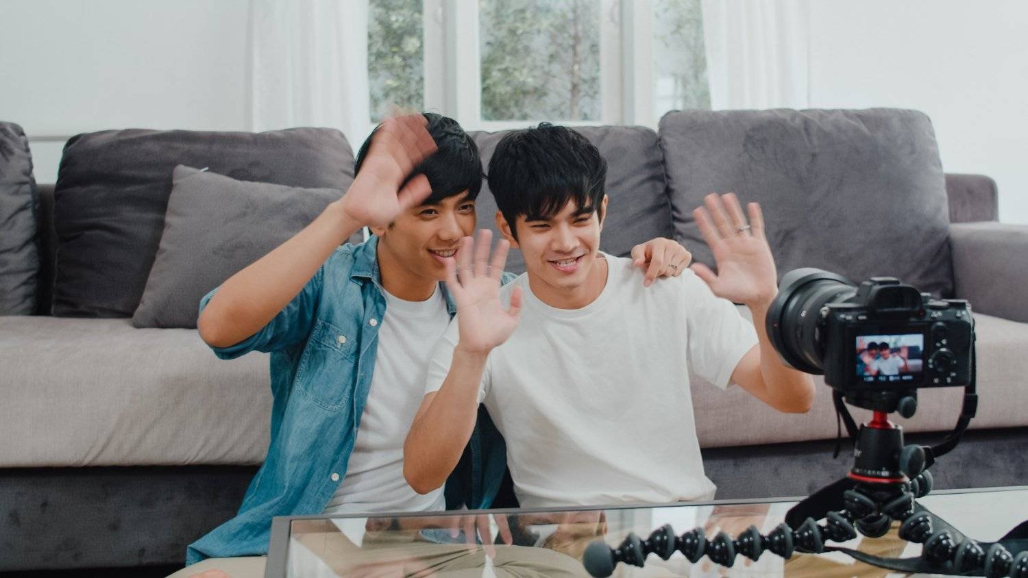 Two Asian content creators waving at a camera. Could be OnlyFans models filming in Australia.