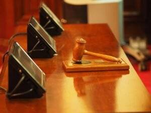 Gavel and monitors on a polished wood table, representing a win for owners corporation.