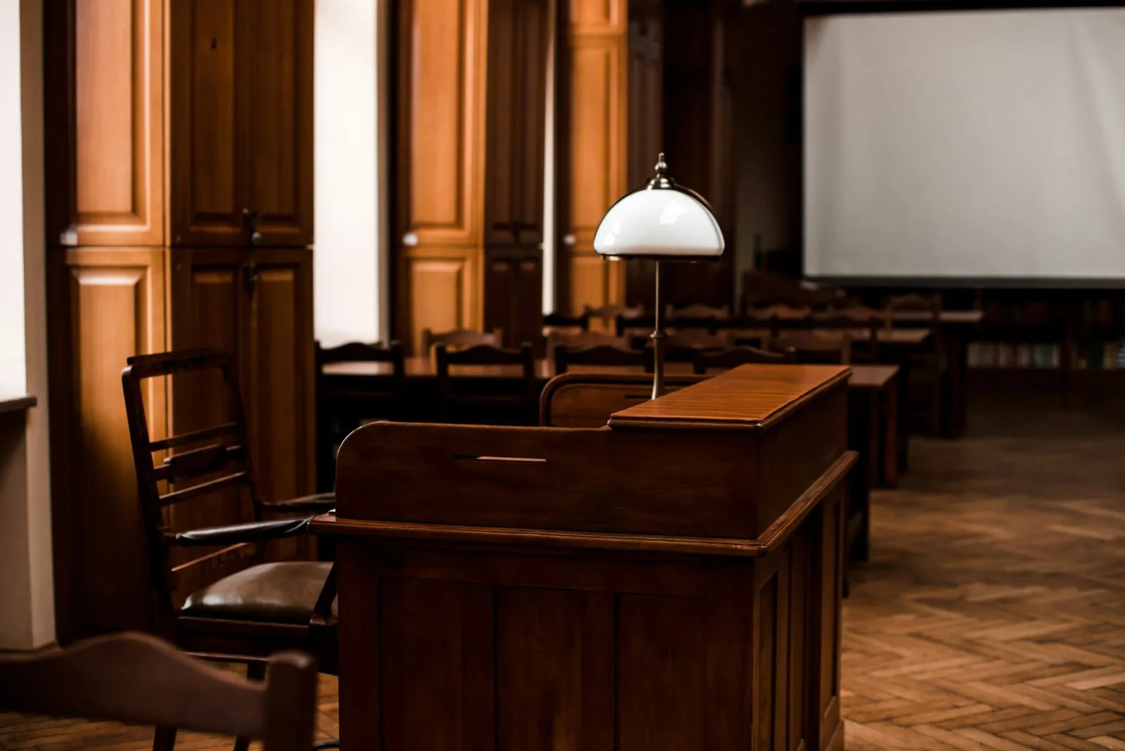 Empty courtroom with wooden furniture, including a podium and chairs, awaiting a new owner liability case.